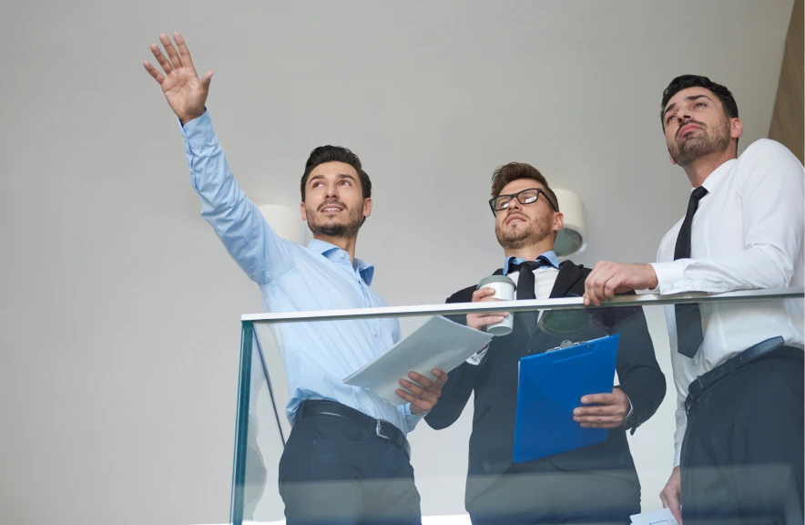 Sesión de trabajo con Deister ERP, personas señalando y tomando notas, fomentando colaboración empresarial.